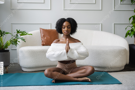 Young woman meditating in living room