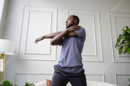 Black man stretching in living room, wellness