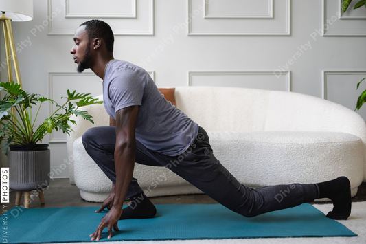 Young African American man stretching in living room