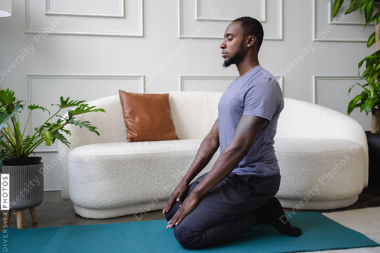 Young man meditating in living room