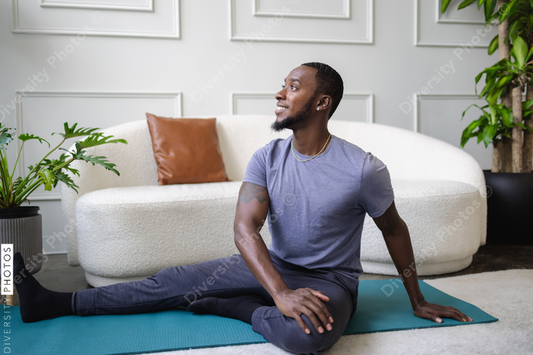 Black man exercises in living room, at home