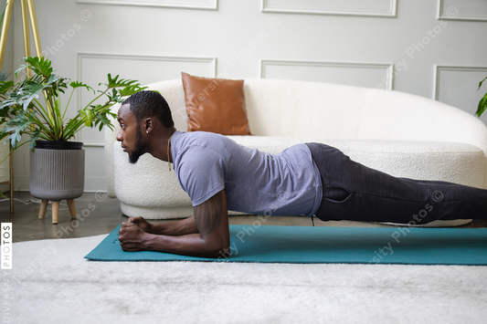 Young man doing plank in living room