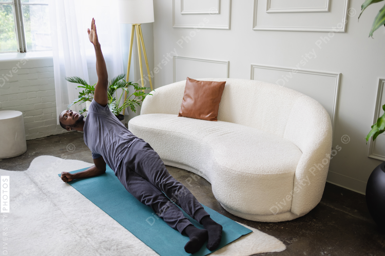 Black man doing plank in living room