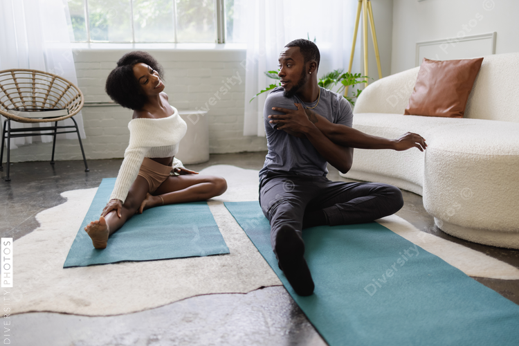 Young couple stretching in living room