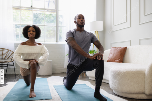Black couple stretching in living room, fitness