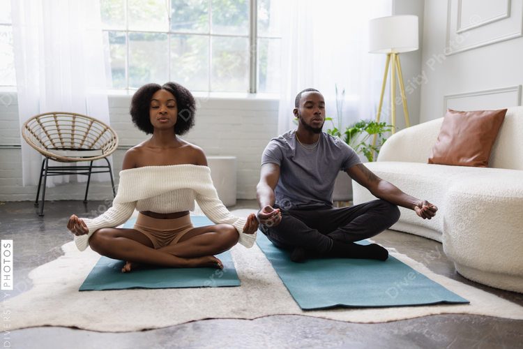 Young couple meditating in living room