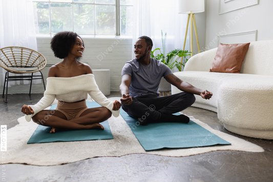 Young couple meditating in living room