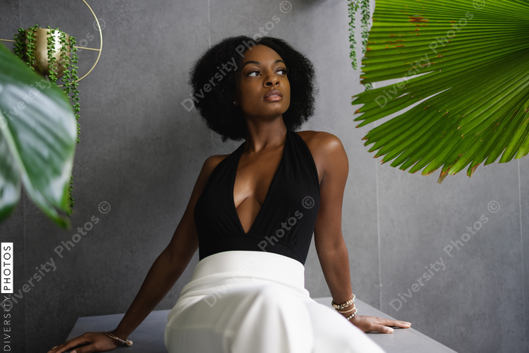 Elegant young woman sitting among plants