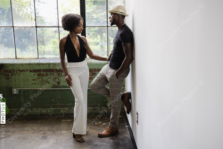 Elegant young couple standing next to window