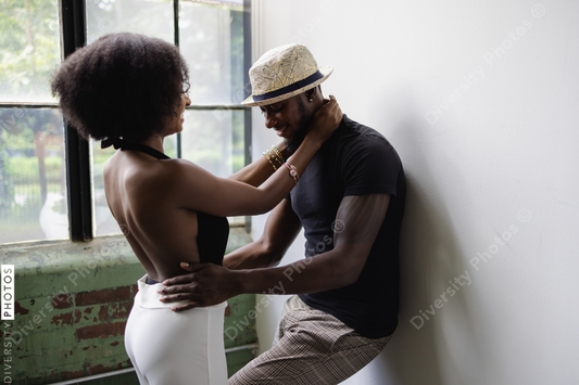 Young couple standing next to window and embracing
