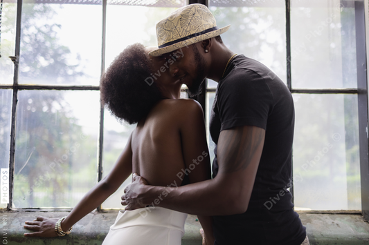 Young couple standing by window and embracing