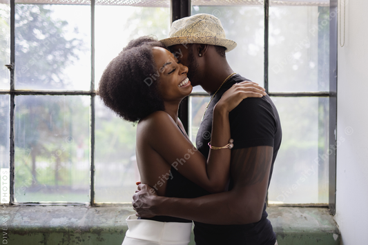 Young  upscale Black couple standing by window and embracing