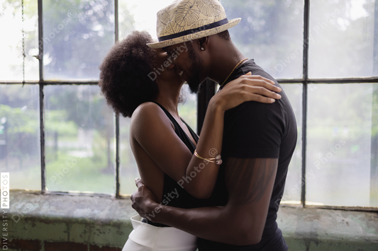 Young couple standing by window and embracing