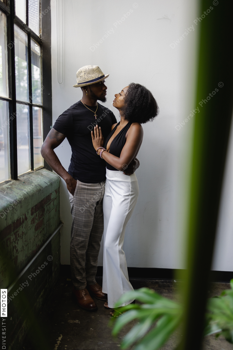 Young couple standing by window and embracing