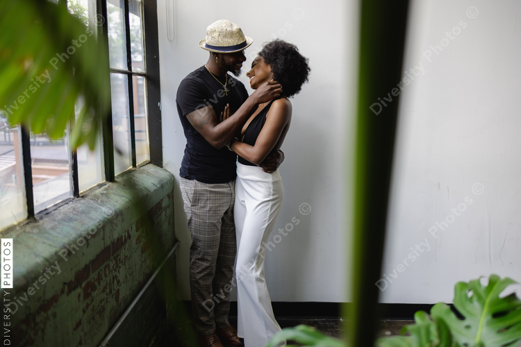 Young couple standing by window and embracing
