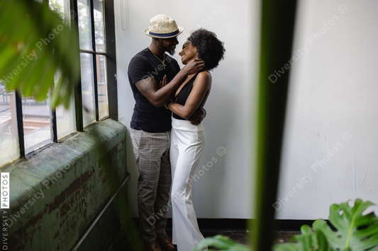 Young couple standing by window and embracing