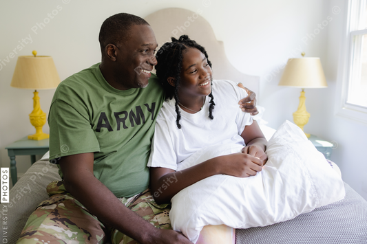 Black military dad talking with daughter at home