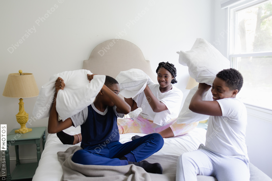 Black siblings having a fun, pillow fight, friendship 