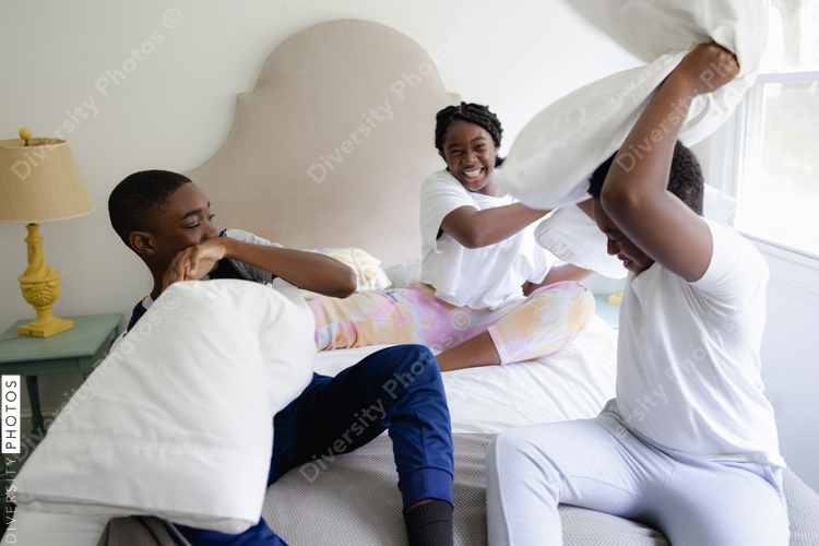 Black siblings having a fun, pillow fight, friendship 