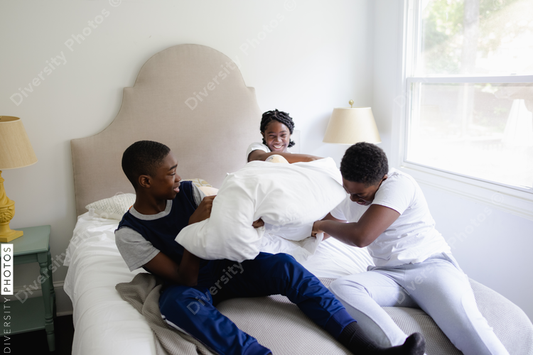 Black siblings having a fun, pillow fight, friendship 