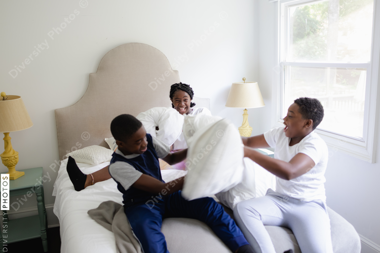 Black siblings having a fun, pillow fight, friendship 