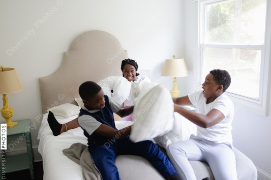 Black siblings having a fun, pillow fight, friendship 