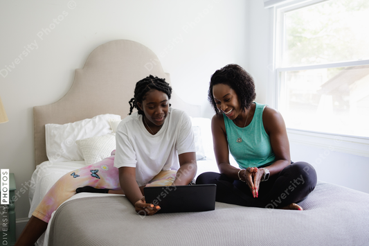 Black mother and daughter doing schoolwork together, education