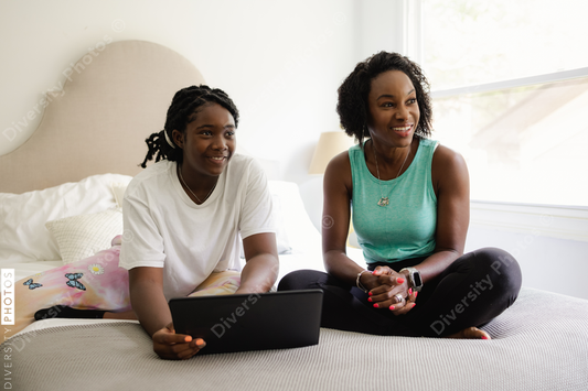 Black mother and daughter doing schoolwork together, education