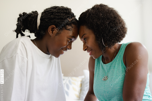 Mother and daughter smiling in bedroom, connectedness, relationship 