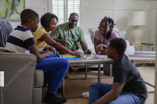 Black army family playing board games at home