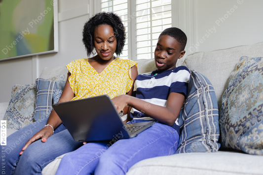 Black son explains schoolwork to mom, on laptop