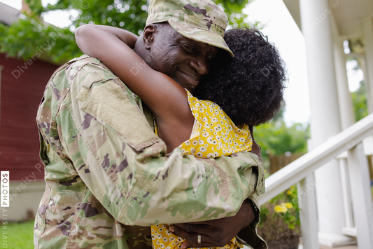Black military man embraces wife as he is welcomed home
