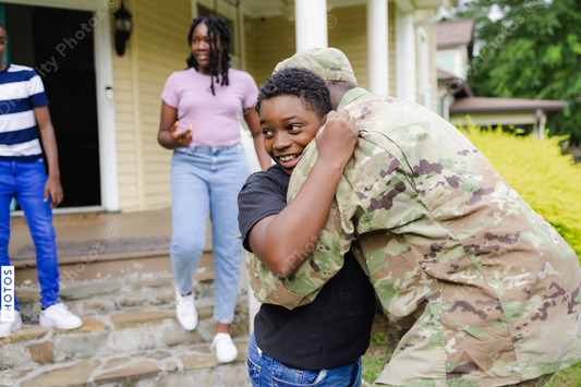 Black military man embraces son as he is welcomed home