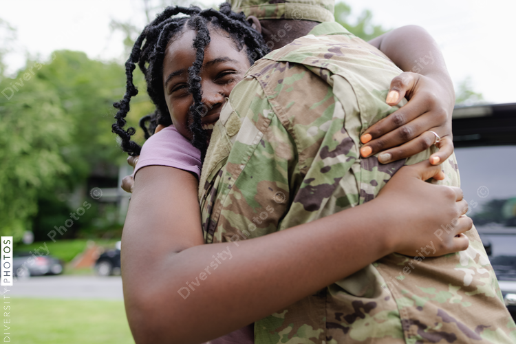 Black military man embraces daughter as he is welcomed home