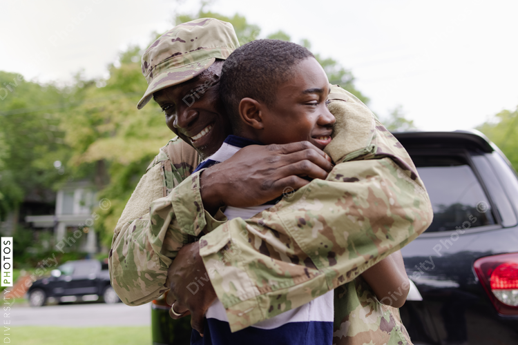 Black military man embraces son as he is welcomed home