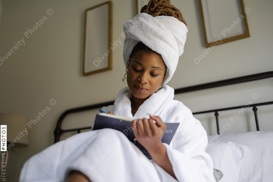 African American Woman in bathrobe writing in notepad