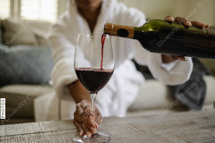 Black Woman pouring glass of wine, close up of hands