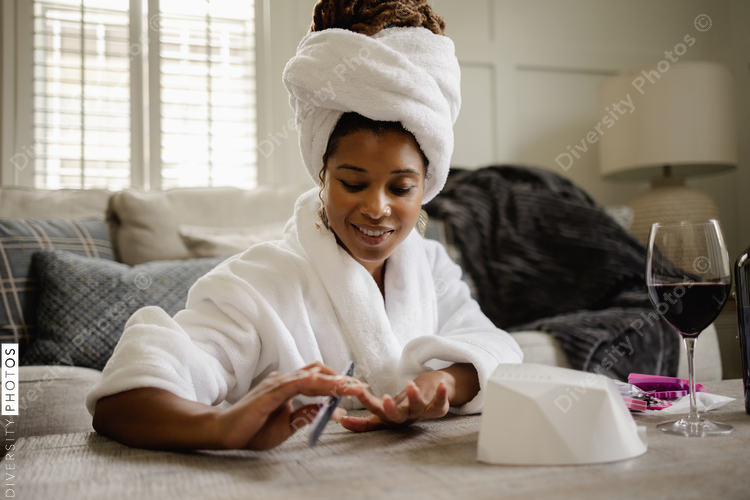 Black Woman in bathrobe doing manicure