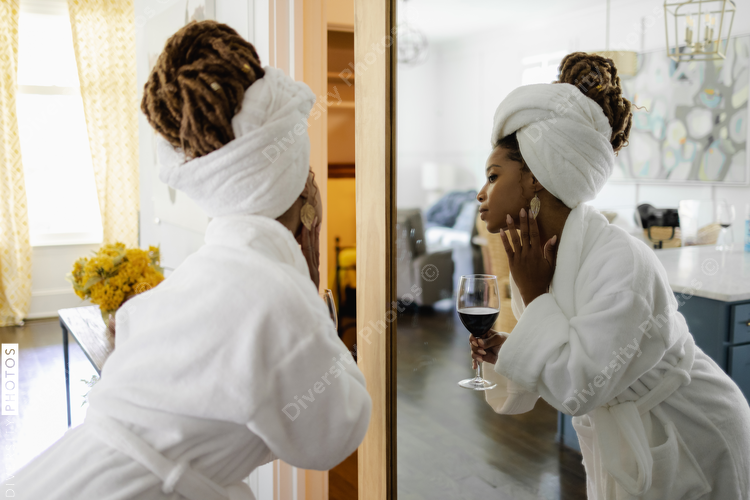 Woman in bathrobe looking in mirror