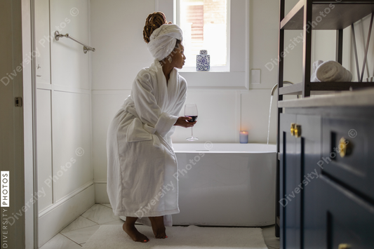 African American Woman in bathrobe preparing bath