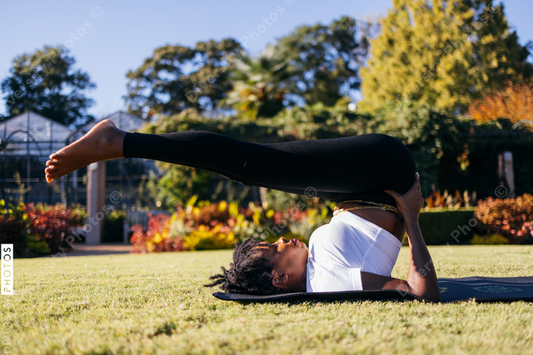 African American woman does yoga in the park