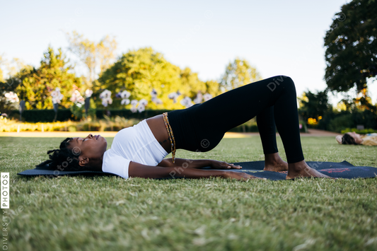 African American woman does yoga in the park
