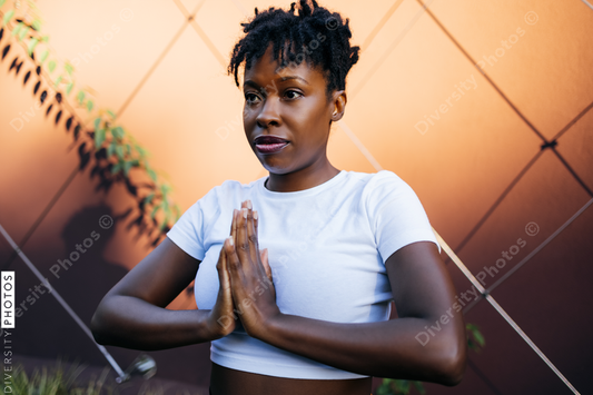 Black woman doing tree pose at sunset