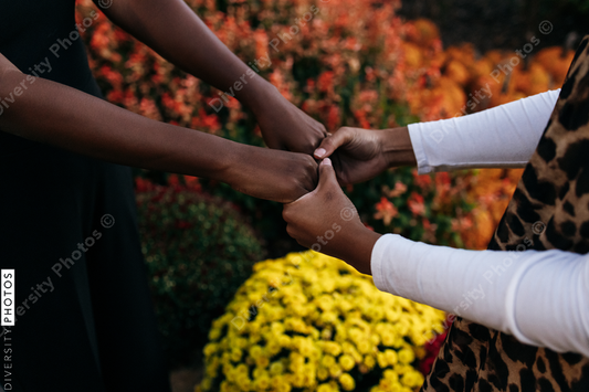Black friends holding hands outdoors, sisterhood, embrace 