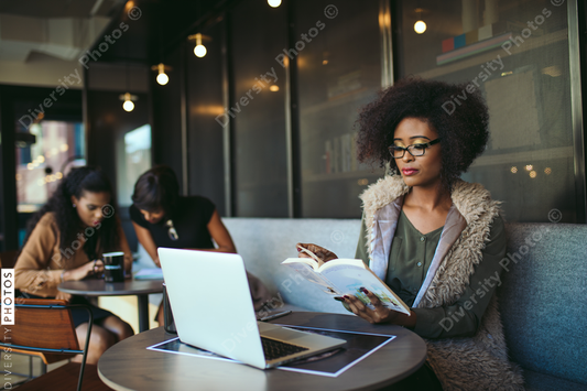 Young businesswoman reading book in office