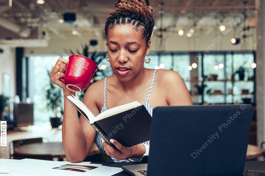 Young businesswoman drinking coffee while working in office