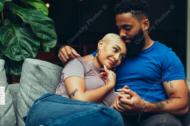 Young couple embracing each other while sitting on sofa