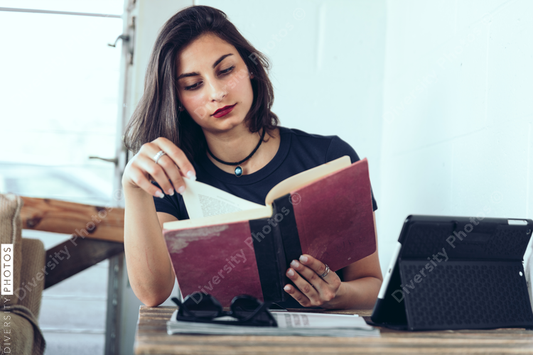 Young woman reading a book while sitting in coffee shop