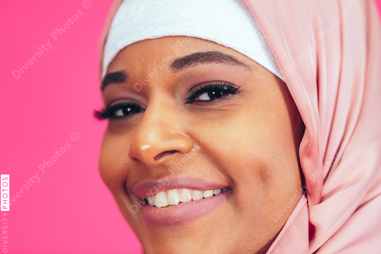 Portrait of smiling woman against pink background