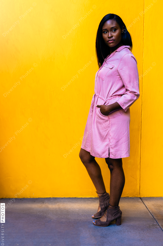 Young woman posing against yellow wall